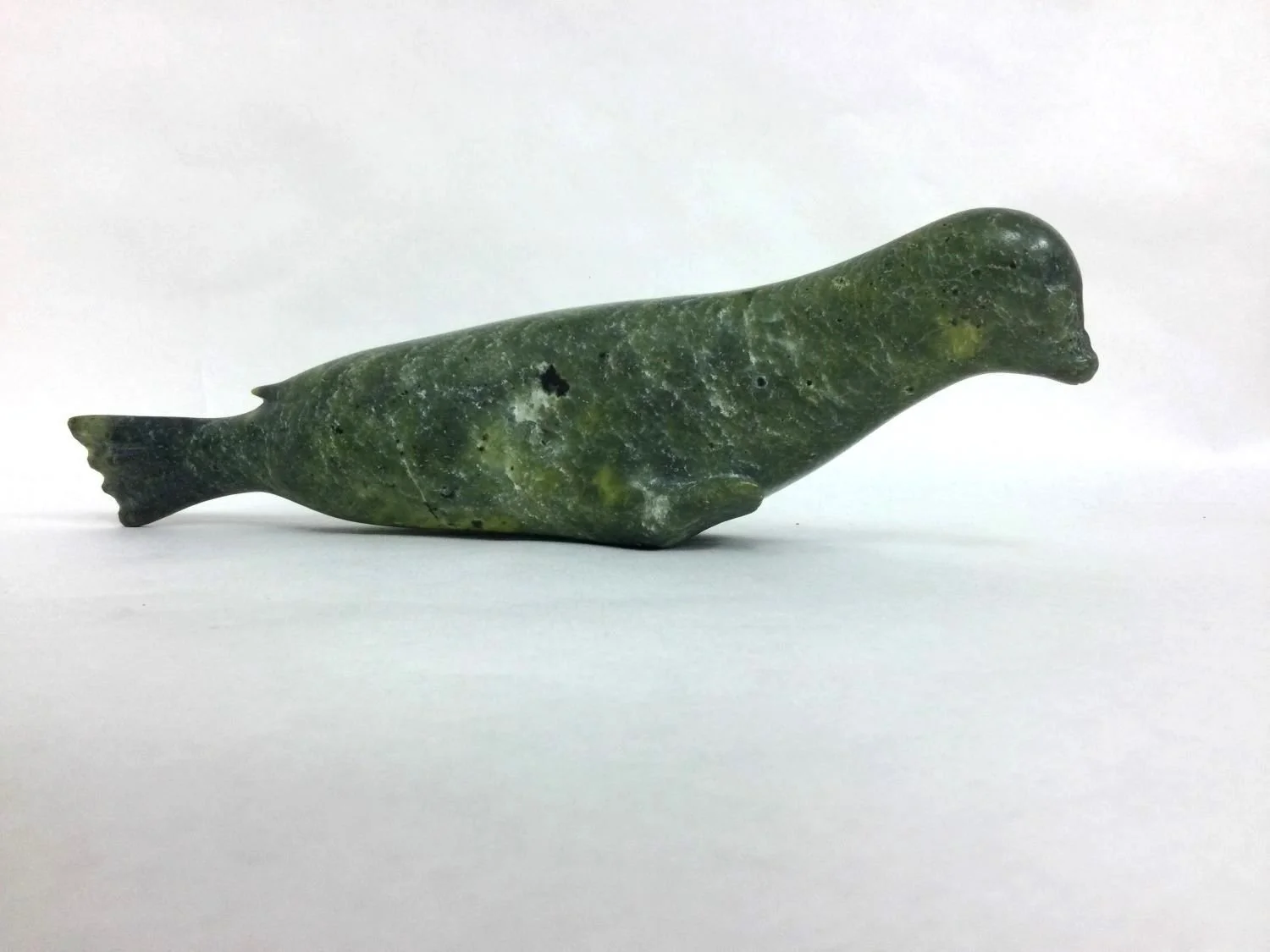 Audla Pee (E7-1043) ᐊᐅᓚ ᐱ (1920-2002) Kinngait/Cape Dorset, ᑭᙵᐃᑦ, Seal (#25.9.6), early 1960s, green serpentine, 3.5 x 11 x 2.25 inches (9 x 4.5 x 5.5 cm), provenance: BC Collection, $1400 Cdn.