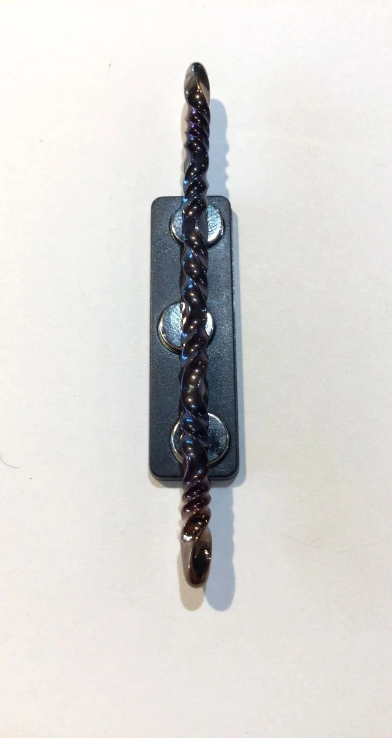 Quantum Wave Tie Pin (#0127E), 2025, steel, magnetic device, 3.25 x 0.15 x 0.15''/8.3 x 0.5 x 0.5cm (including magnet: 3x0.5x0.25'' 7.7x1.5x1cm) (just magnet: 1.75x0.5'' 4.5x1.5cm), $200 Cdn.