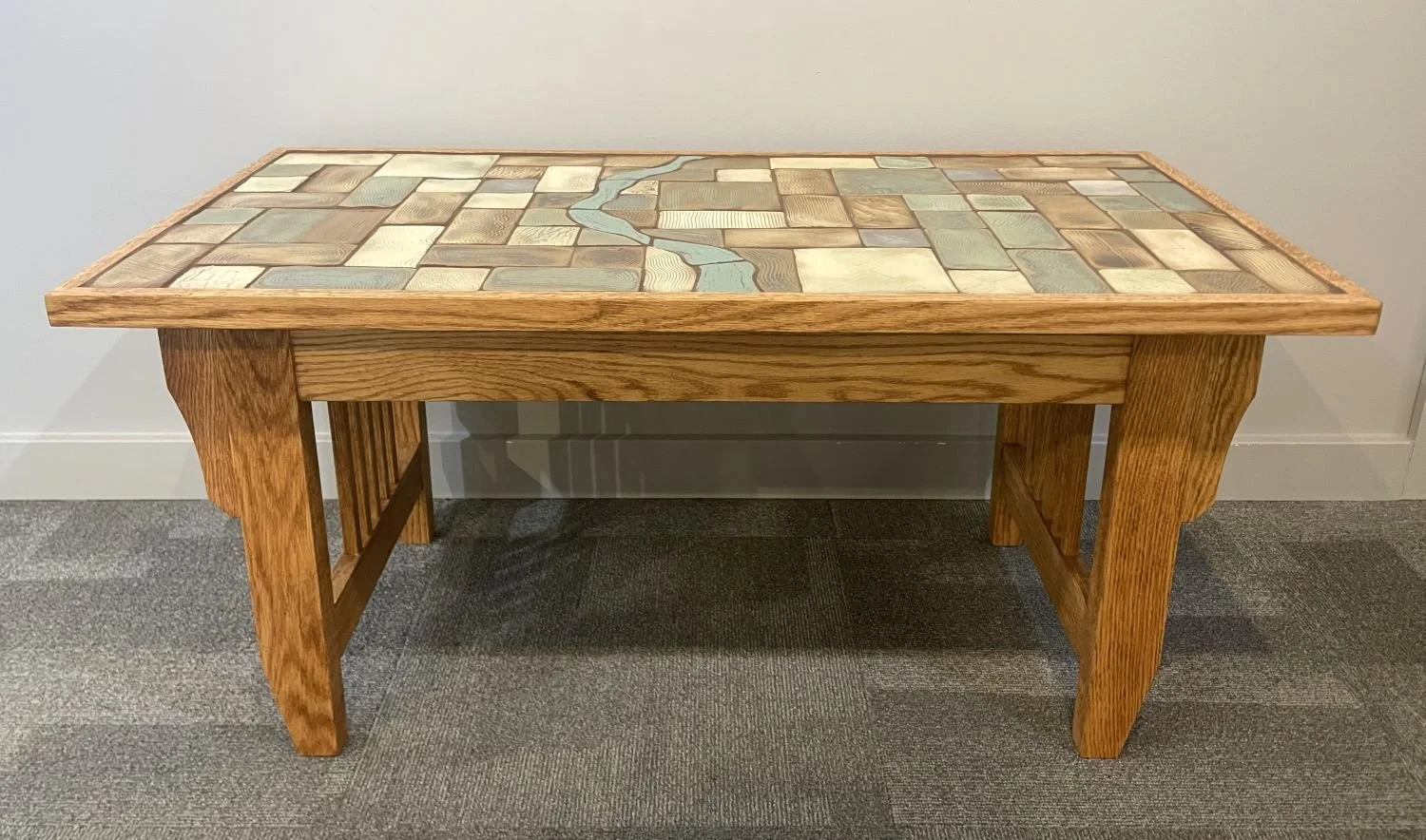 Prairie River Coffee Table (#26.5.23), 2026, handbuilt golden oak, carved and glazed tile top, 19 x 21.5 x 41 inches (48 x 55 x 104 cm), $2900 Cdn.