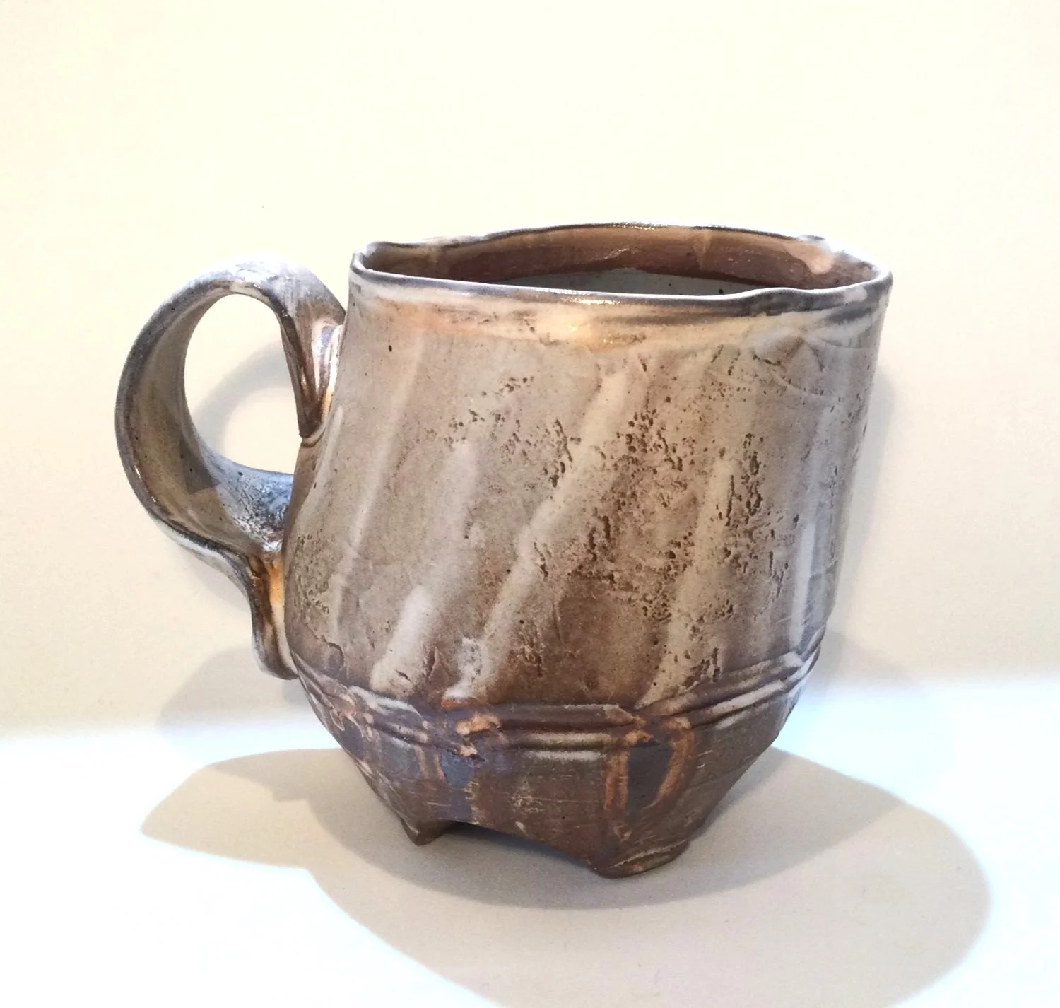 Confluence - Footed Mug (#26.2.79), 2026, low soda-fired earthenware, 3.75 x 5 x 3.5 inches (10 x 13 x 9 cm), $90 Cdn.