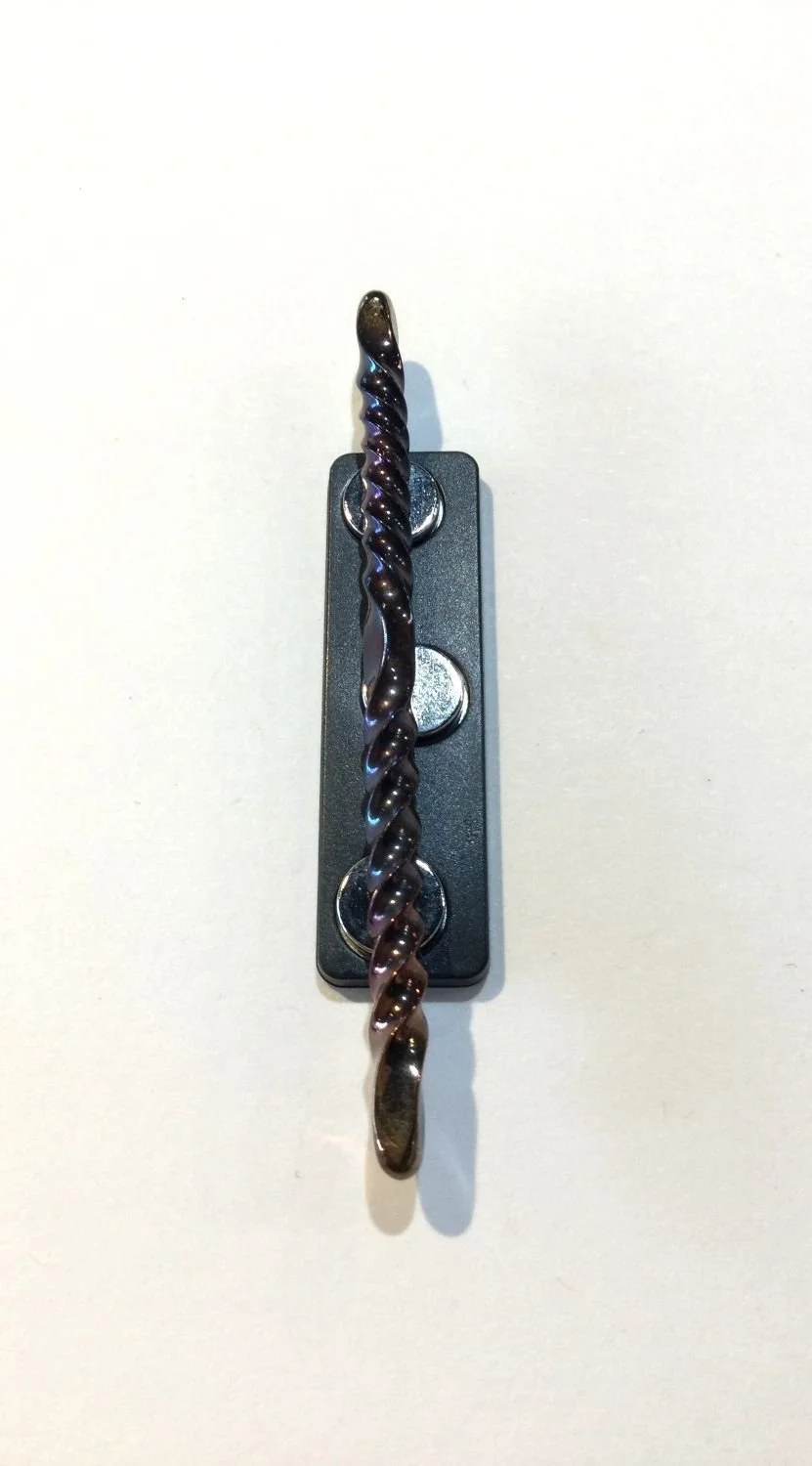 Quantum Wave Tie Pin (#0127G), 2025, steel, magnetic device, 3 x 0.15 x 0.15''/7.7 x 0.5 x 0.5cm (Including magnet: 3x0.5x0.25'' 7.7x1.5x1cm) (just magnet: 1.75x0.5'' 4.5x1.5cm), $200 Cdn.
