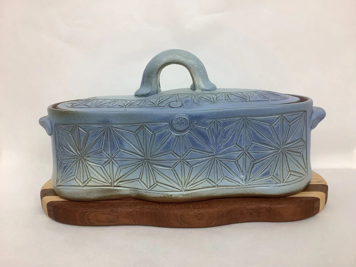 Kumiko Blue Skies Casserole Dish with Striped Wood Trivet (#24.06.21), hand carved stoneware with handmade oak, cherry, walnut trivet, 6.5 x 12.5 x 6.5 inches (16.5 x 32 x 16.5 cm), $275 Cdn.