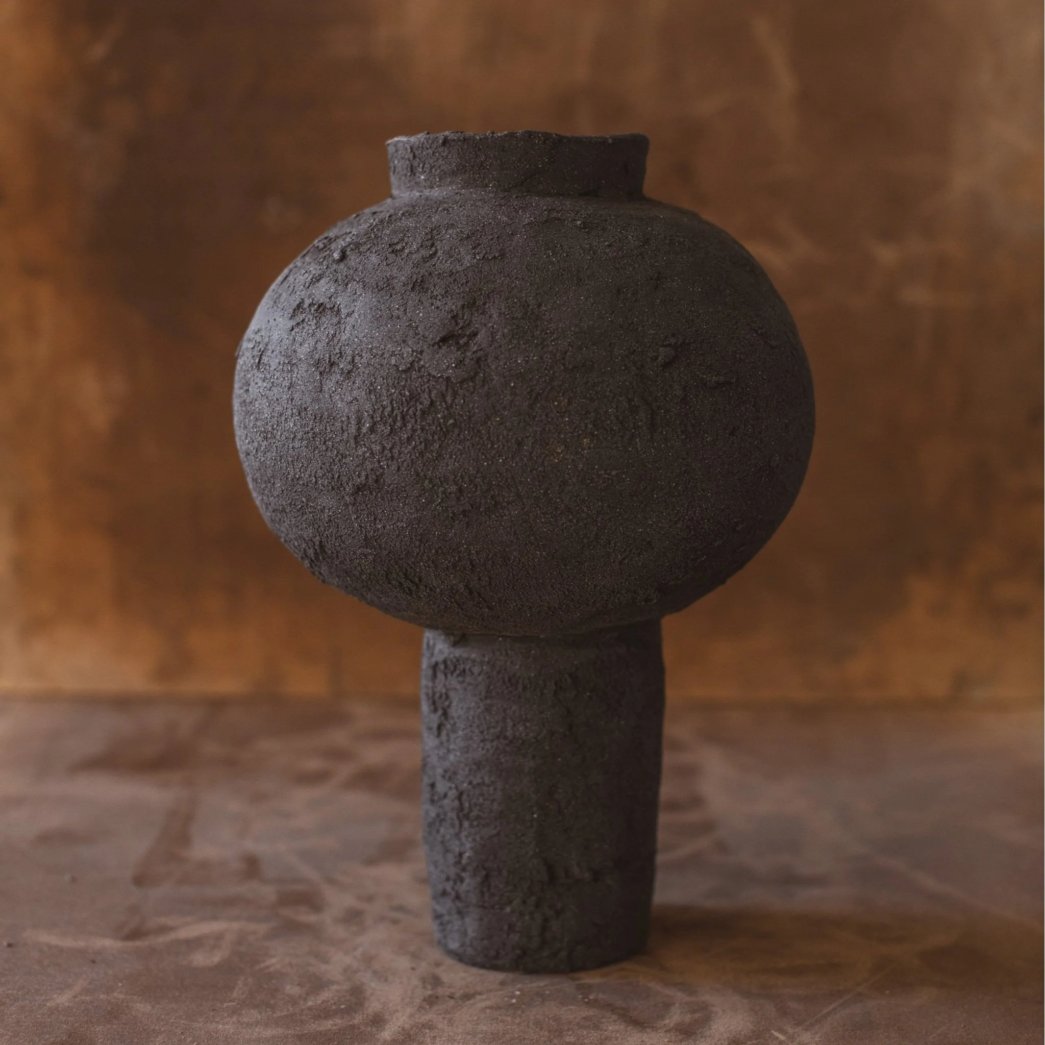 Handmade ceramic moon jar with textured black clay surface