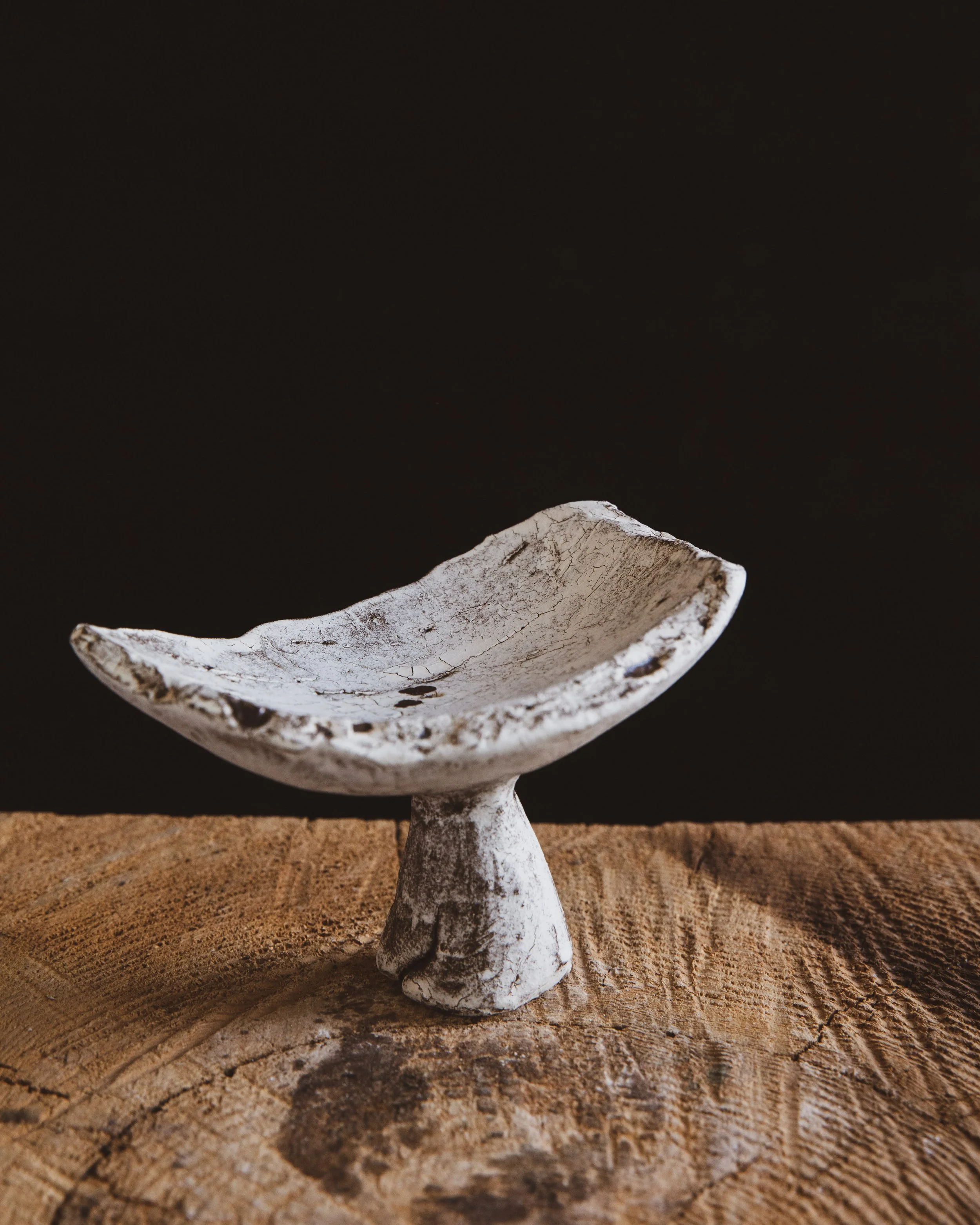 A white ceramic object with a dark cracking pattern