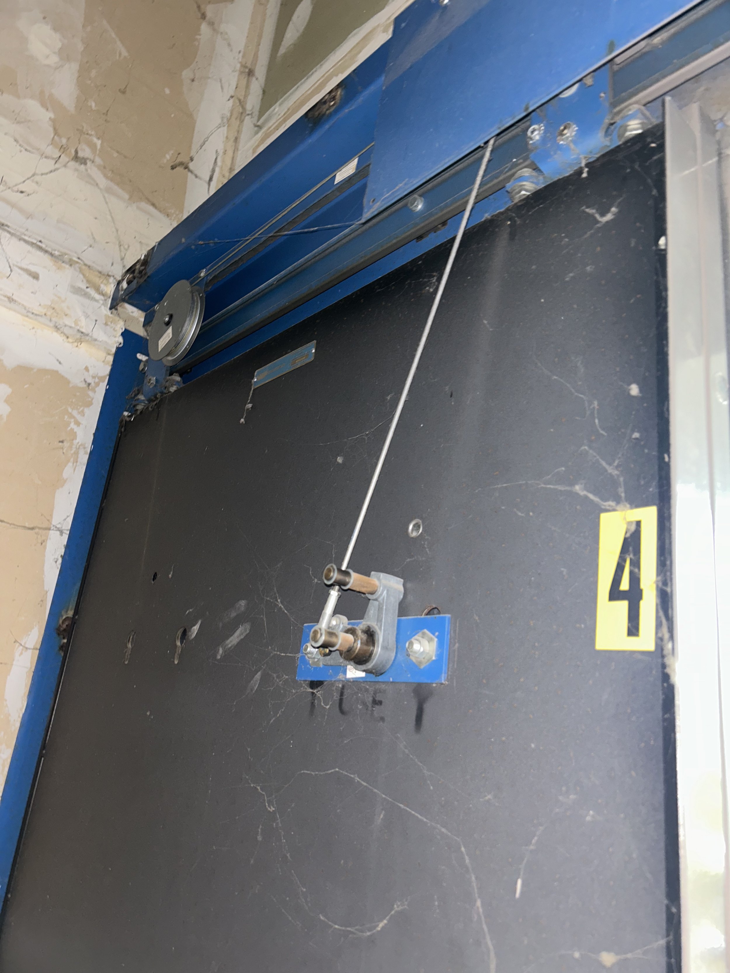 Elevator hoistway with missing door pickup rollers and cobwebs