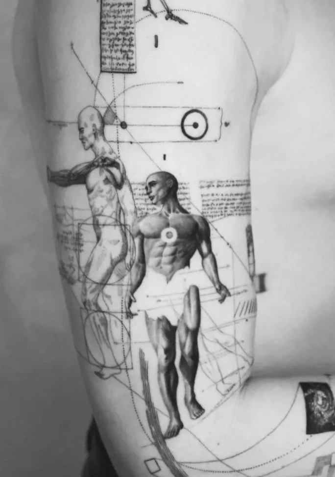 A tattoo of Leonardo da Vinci's Vitruvian Man with muscular human figures and technical diagrams.