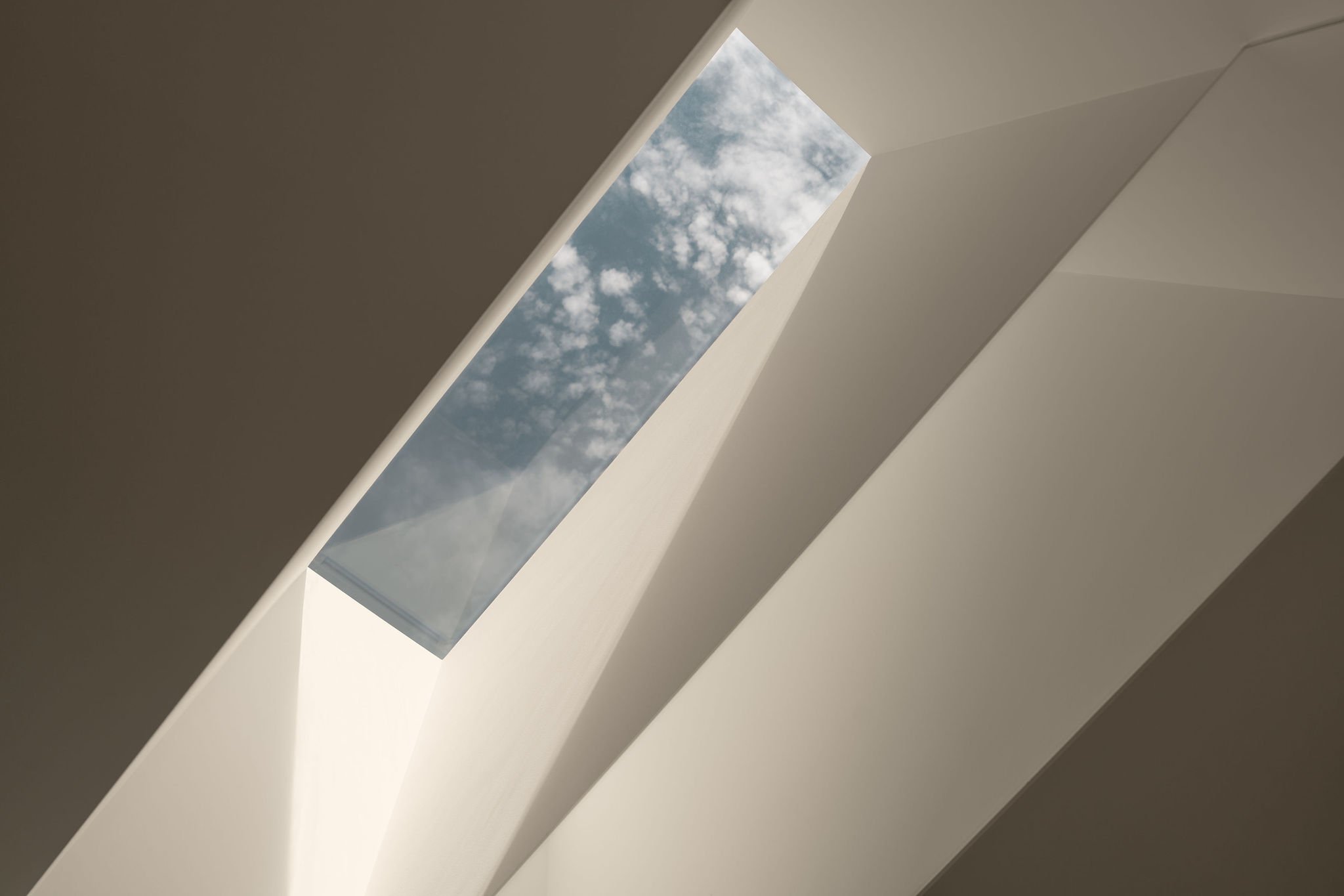 Architectural ceiling detail with elongated rectangular skylight casting soft natural light into the space