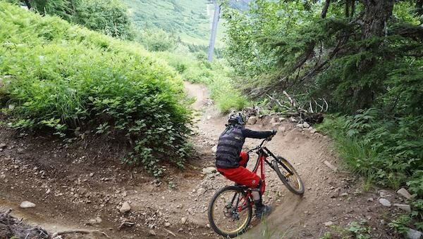  Biker making a tight turn down Alyeska Mountain 