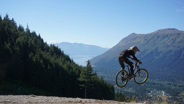  Biker launching off a jump on Alyeska Mountain 