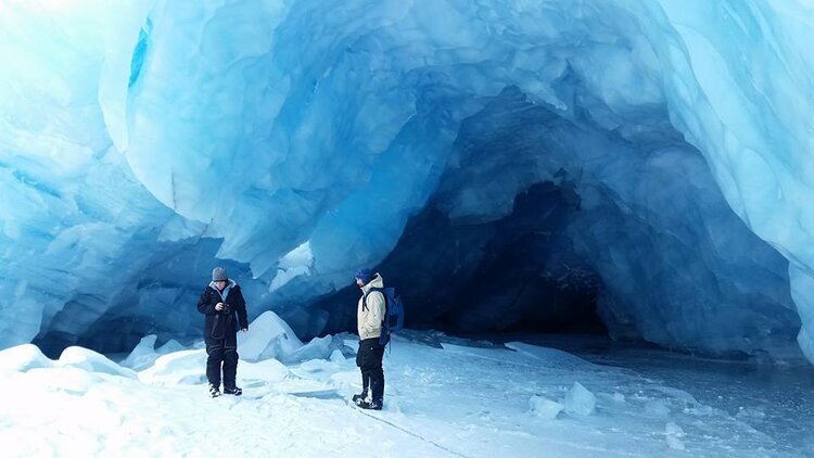  Two people at the entrance of an ice cave on a tour with Alaska Backcountry Access 