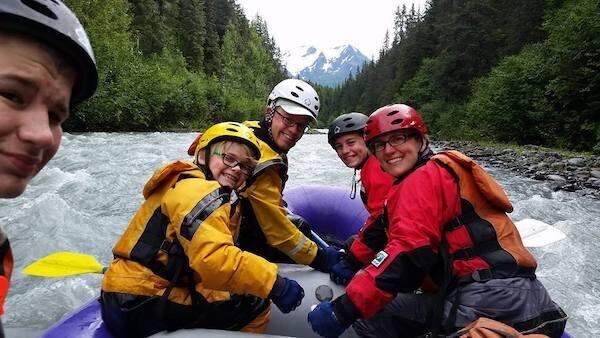  People in a raft on a river with Alaska Backcountry Access.  