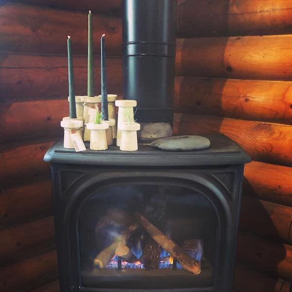  A wood stove with a fire in the corner at Mother Hubbard’s Cupboard 