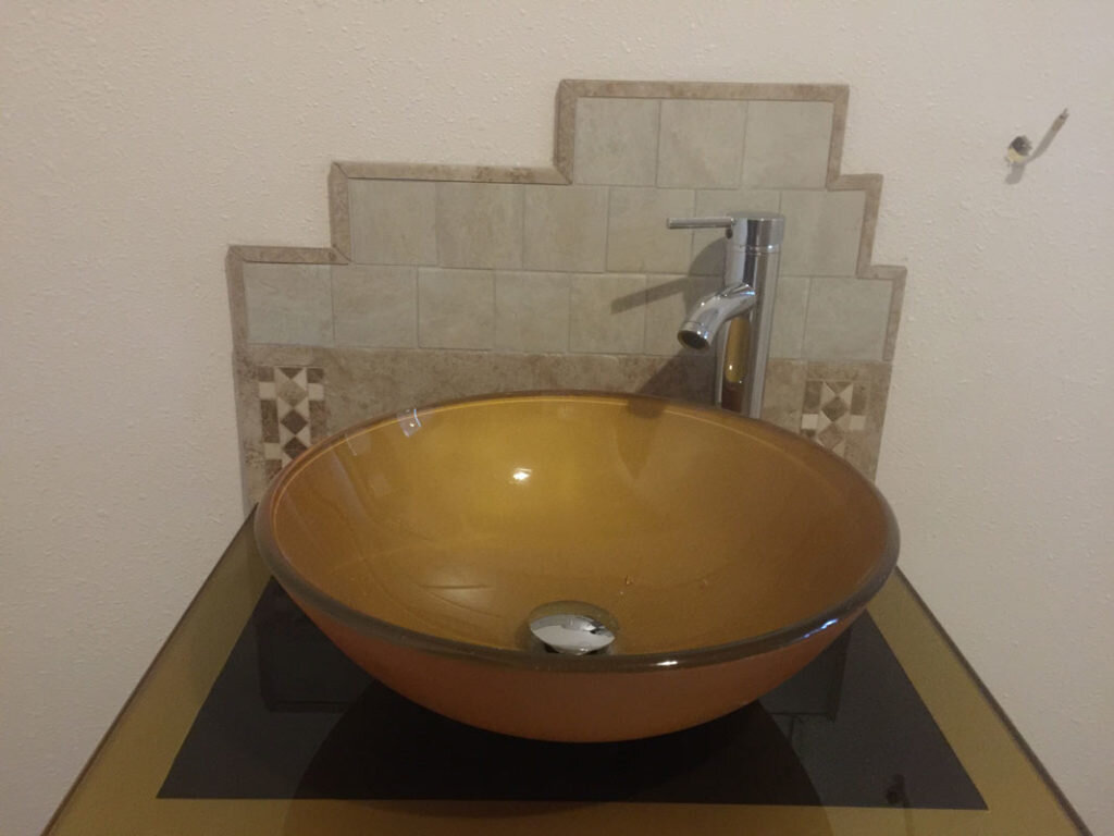  A bathroom sink with a glass decor background done by Alaska Stone Care 