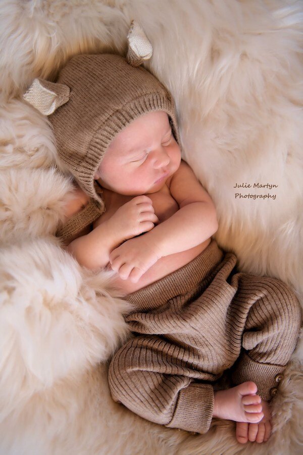  A baby sleeping with a hat on a fuzzy blanket with photo taken by Julie Martyn Photography 