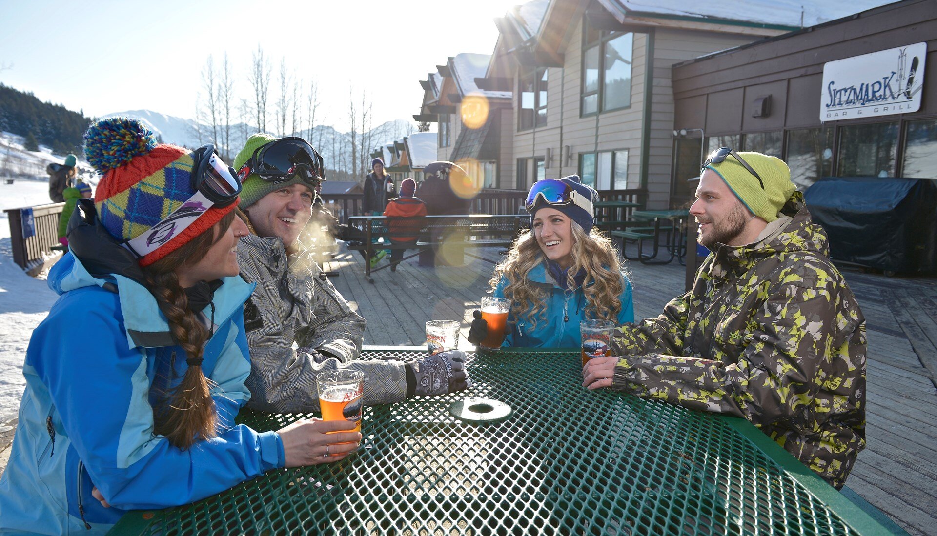  Skiers enjoying a drink on the deck of the Sitz Mark  