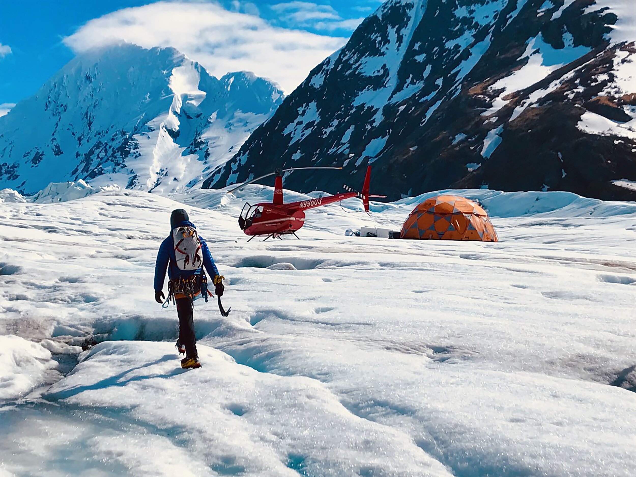  Tents on a ice field with a hiker 