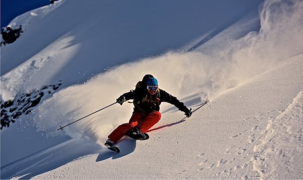  Skier skiing fast on side of mountain with Chugach Powder Guide 