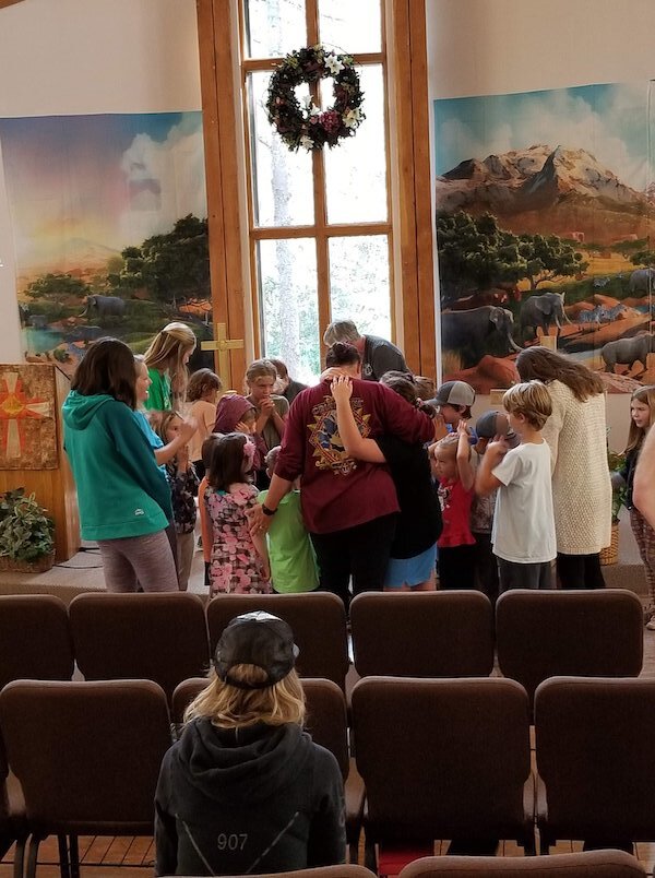  People in prayer and Girdwood Chapel 