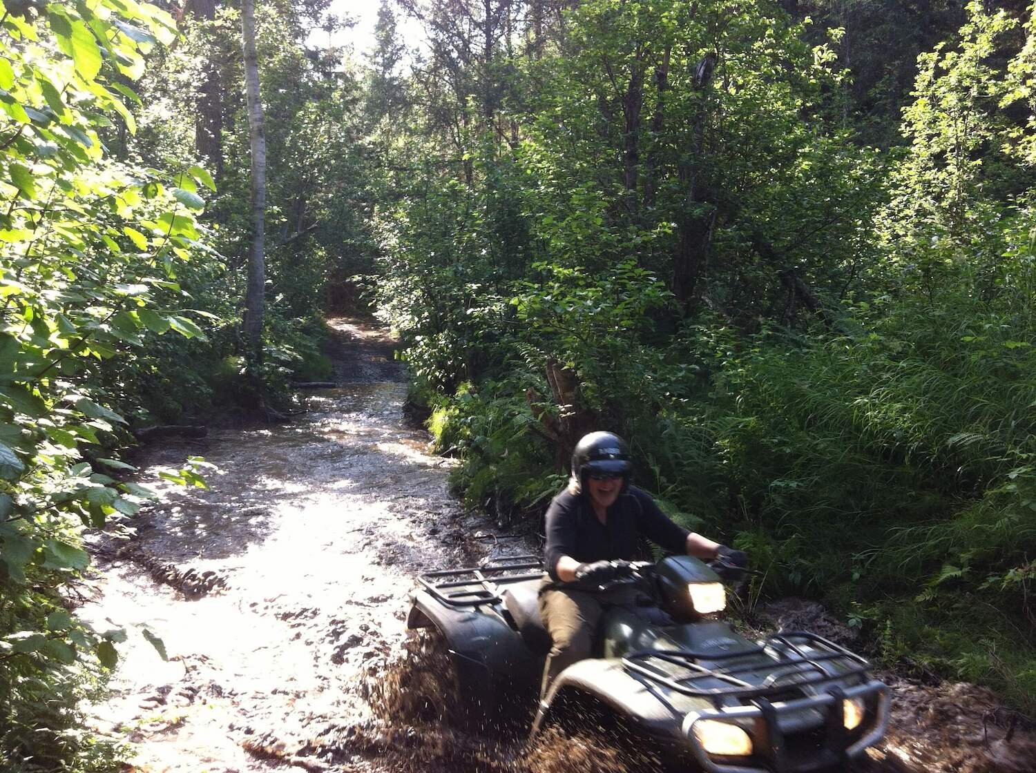  ATV rider going through a large puddle of water on a tour with Alaska Adventure 