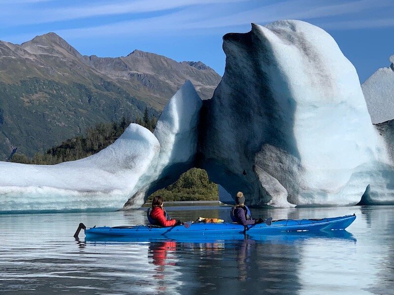  A kayaker floating next to glacier with Chugach Adventure Guides 
