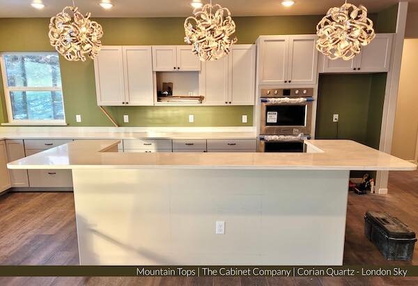  A green-colored kitchen with white quartz from Mountain Top Countertops 
