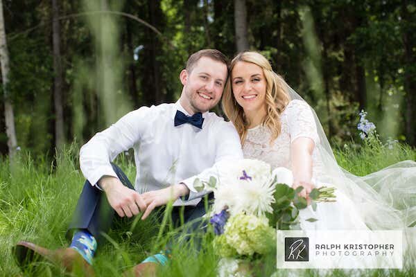  A bride and groom sitting in a field  photo by Ralph Krisopher Photography 