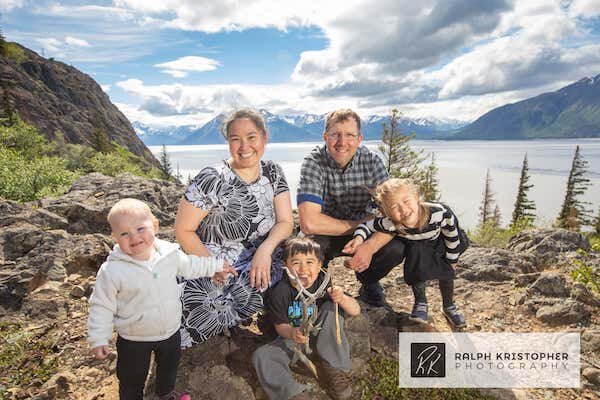  A family sitting on a rock with the Cook Inlet in the background  photo by Ralph Krisopher Photography 