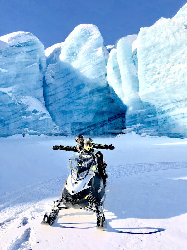  A man on a snowmobile in front of a glacier on a tour with Alaska Wildguides 