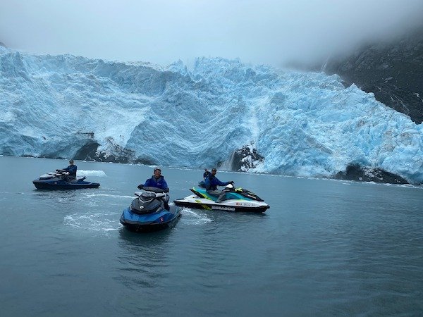  Three people in front of a glacier on an Adventure Jet Ski tour 