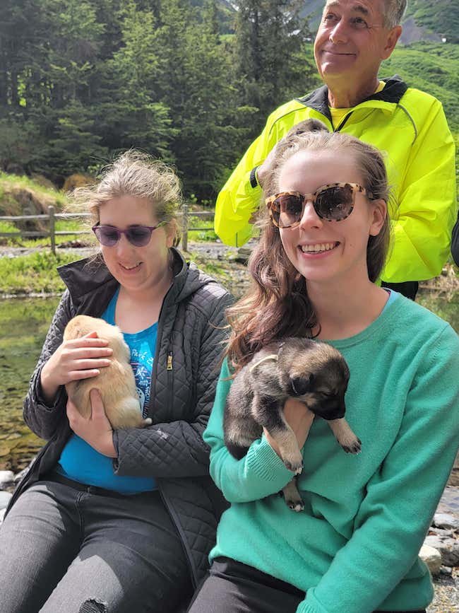  Two women holding puppies at Girdwood Sled Dog Adventure 