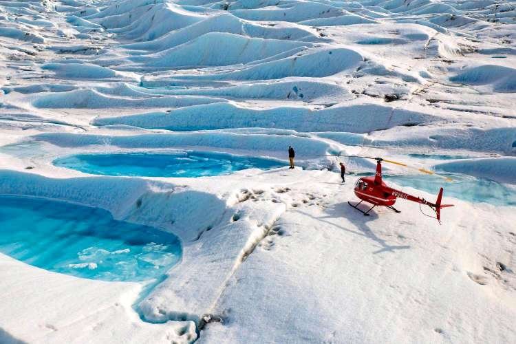  Alpine Air helicopter next to a glacier pool 