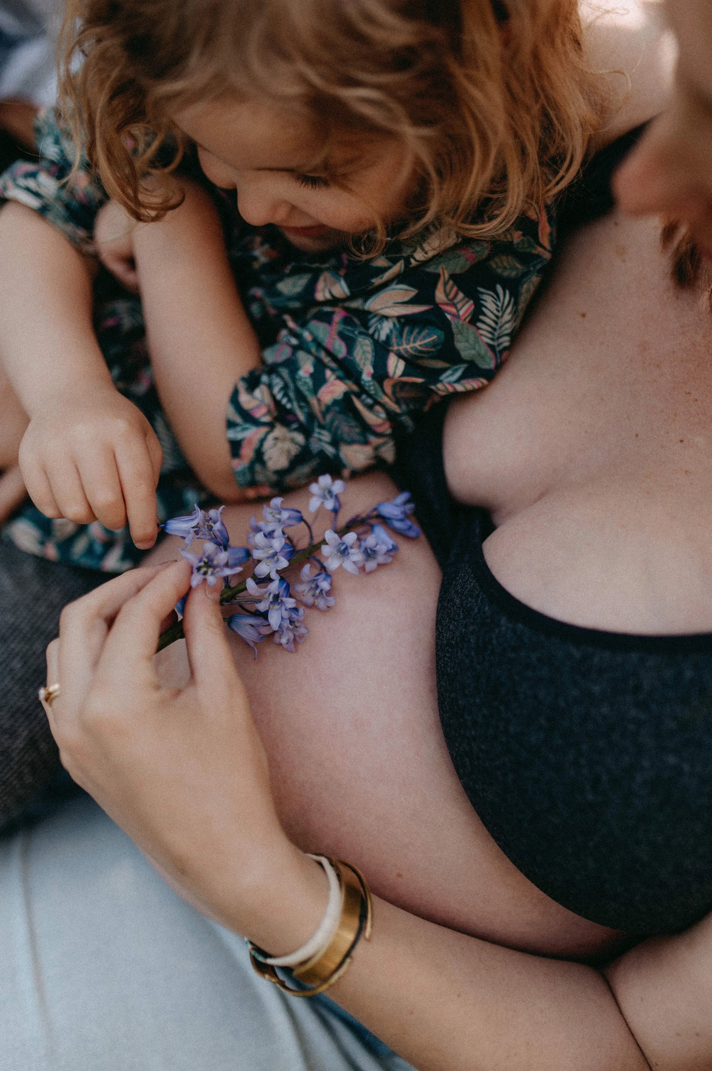 une petite fille regardant le ventre rond de sa maman