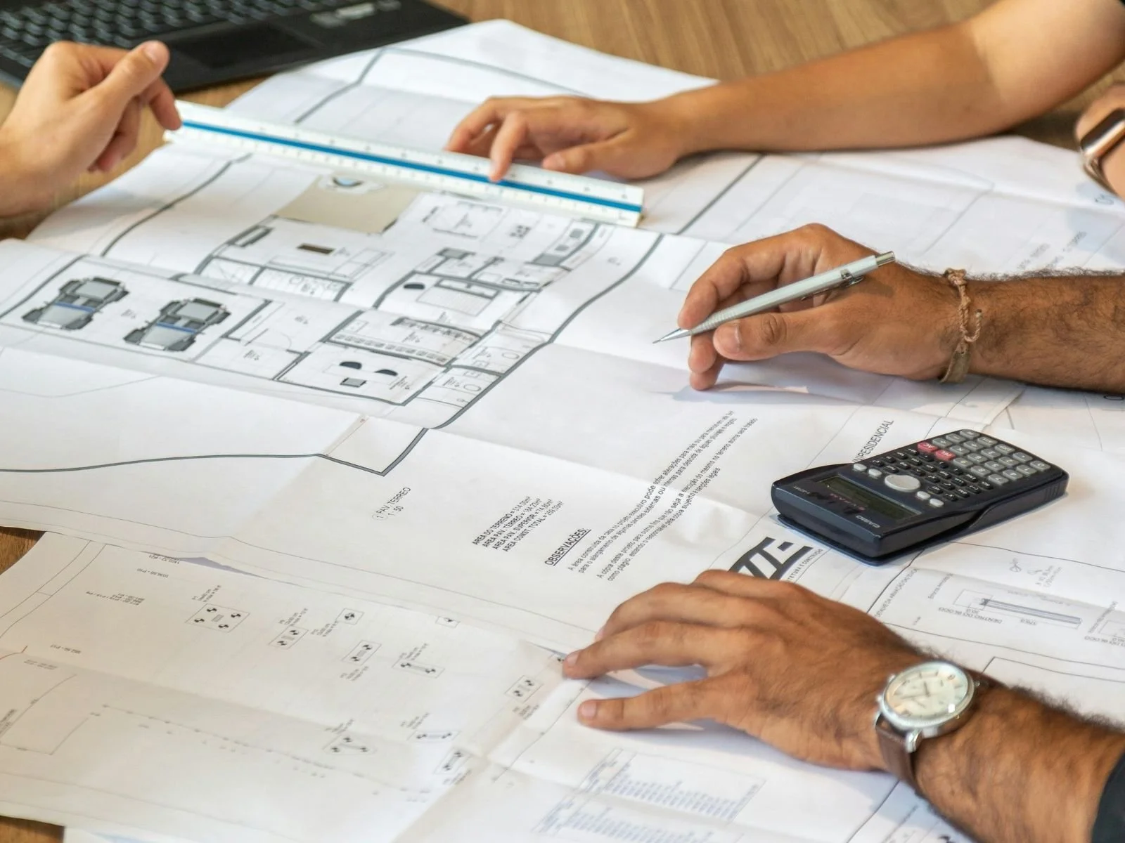Professionals reviewing architectural plans and permit documents at a desk