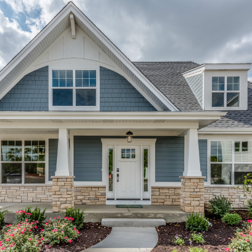 Front exterior of a newly constructed residential home with a covered porch and landscaped entrance.