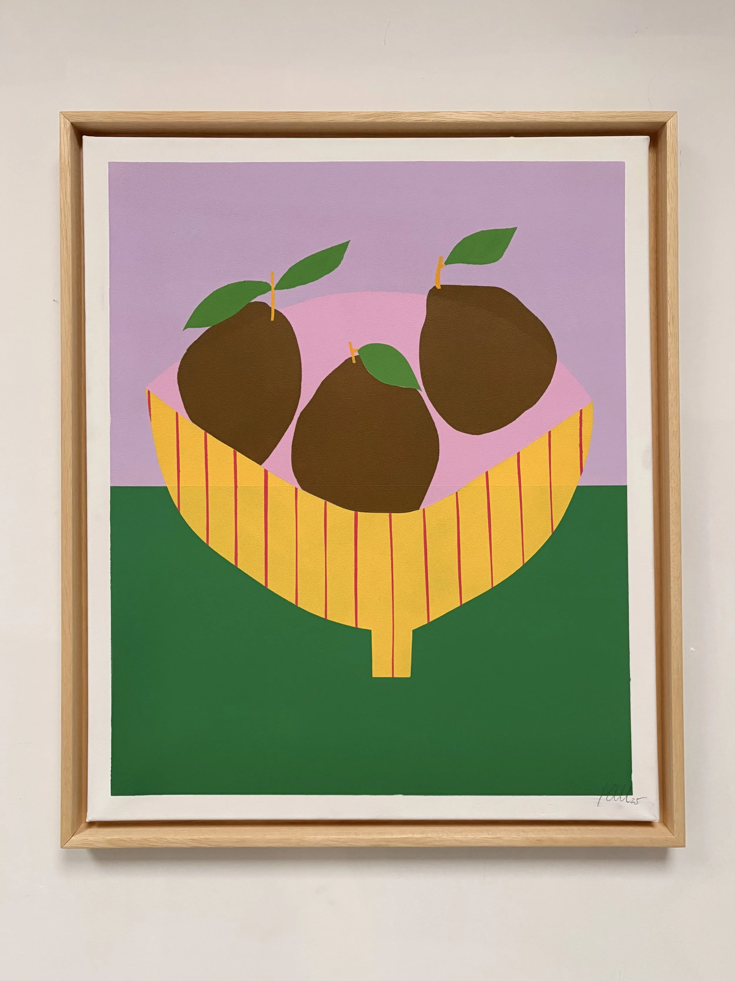 3 brown pears in a pink and yellow bowl on a green table
