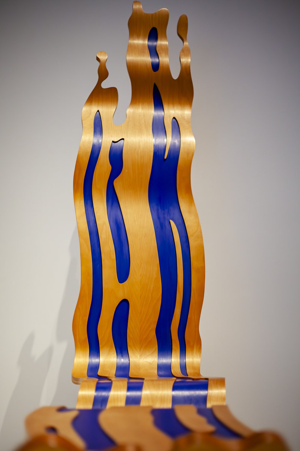 Photograph of the Brushstroke Chair and Ottoman by Roy Lichtenstein, constructed from laminated and lacquered white birch plywood. Captured under controlled museum lighting to accurately render surface sheen, color contrast, and sculptural form while
