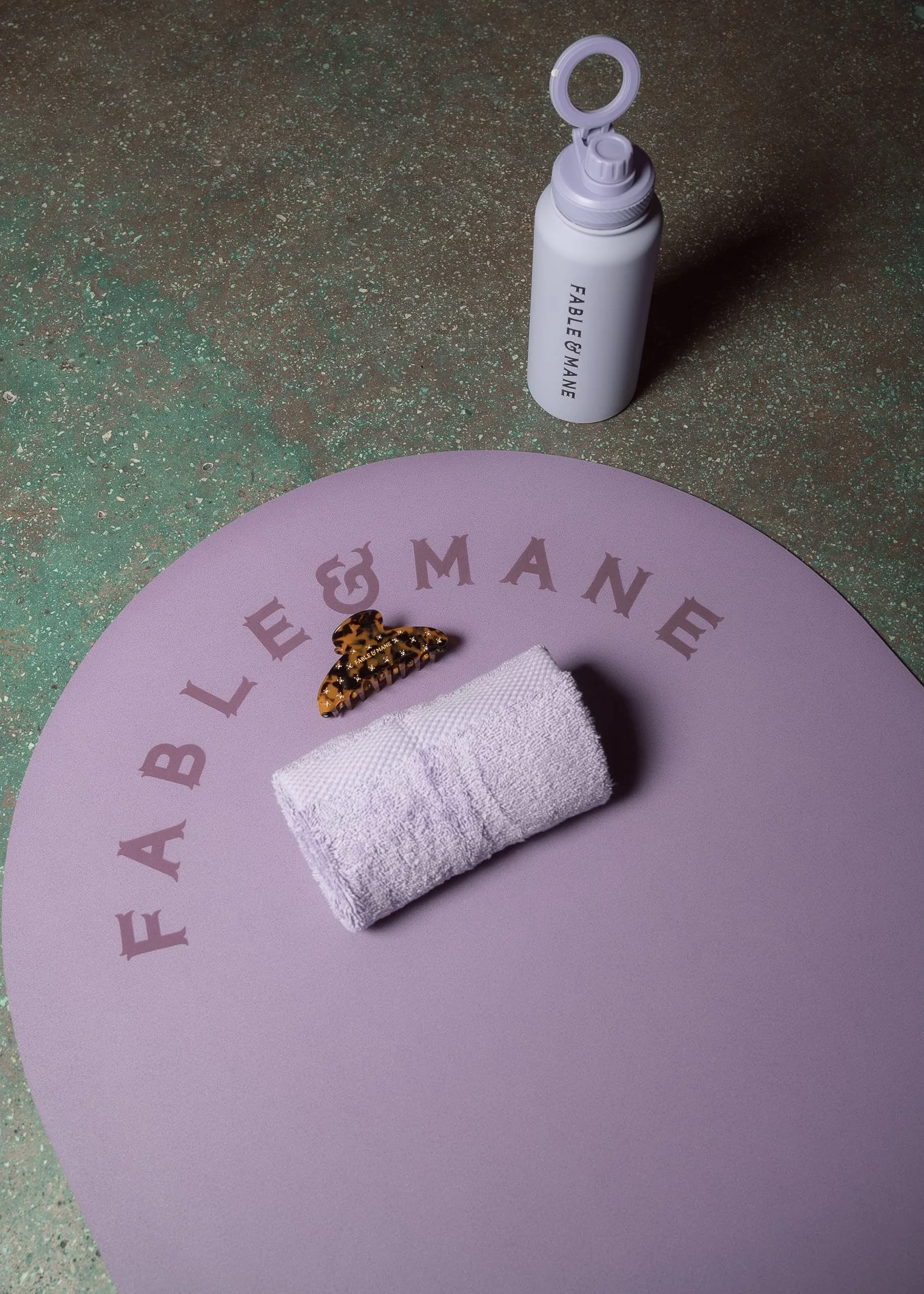 Detail capture from the Fable & Mane launch event at Mimi Yoga in Wynwood — branded mat, towel, and water bottle setup before the session.