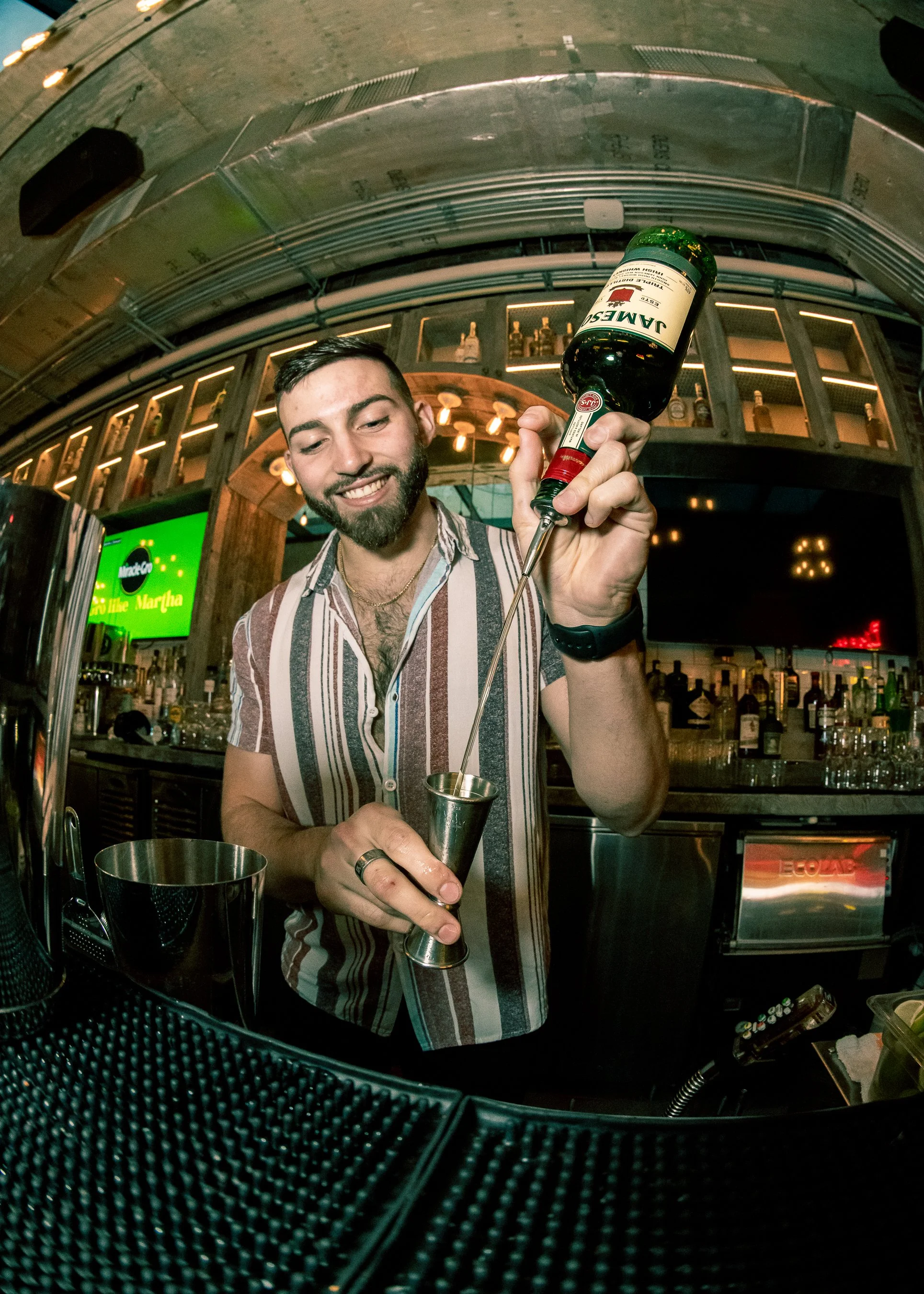 Alejandro Gil carefully measuring Jameson Irish Whiskey into a jigger behind the bar at Bodega Taqueria y Tequila in Coconut Grove.