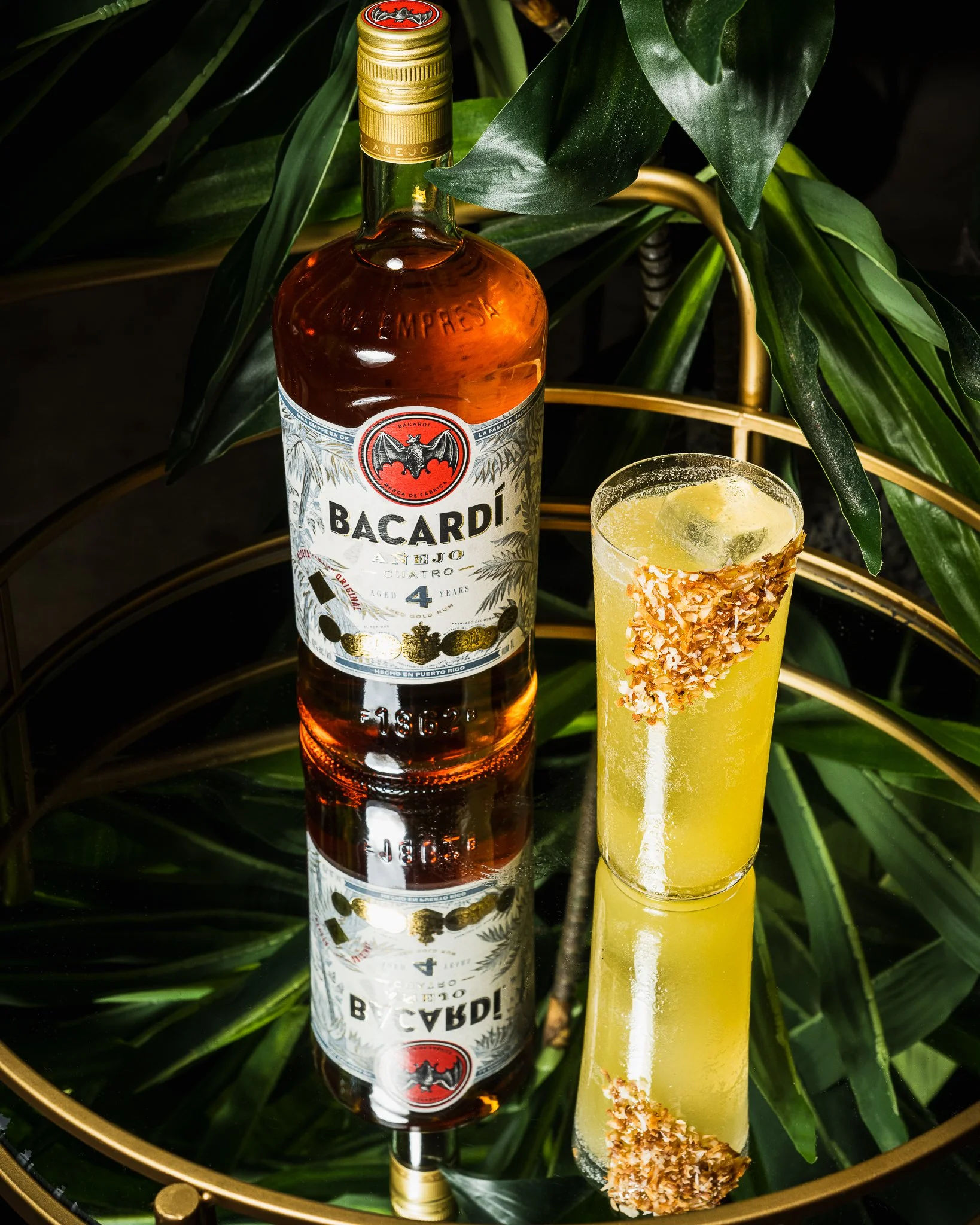 Styled cocktail photograph featuring a Bacardi Añejo Cuatro bottle with a tropical rum cocktail crafted by bartender Rodrigo Tubert, shot for Orilla restaurant on South Beach.