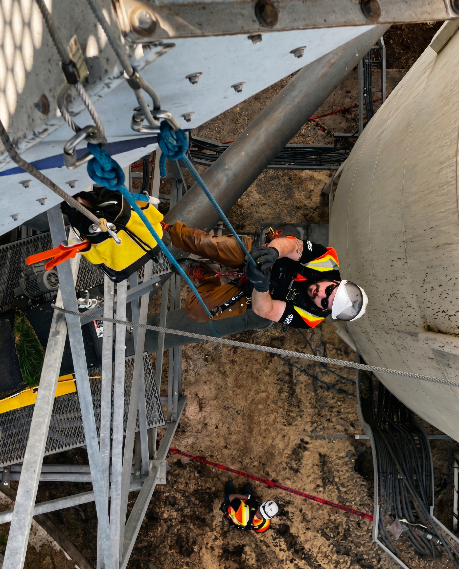 Safe rope access rigged at multiple elevation points across the structure, with ground support in position and dual-rope redundancy throughout.