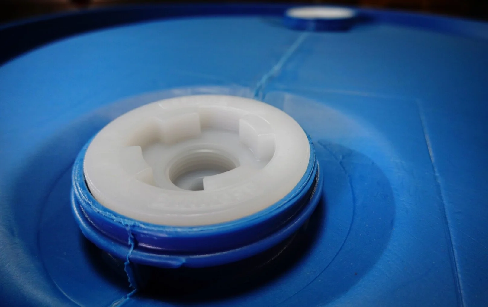Close-up of a white and blue cap on a blue plastic container.