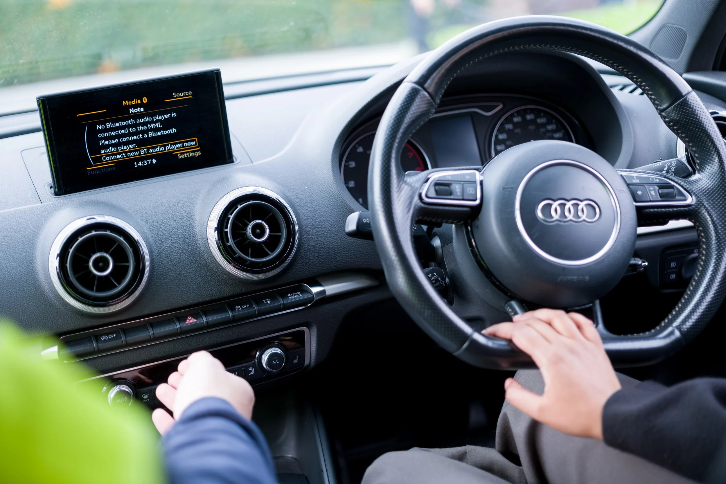 Driver holding the steering wheel during a test drive to assess vehicle performance