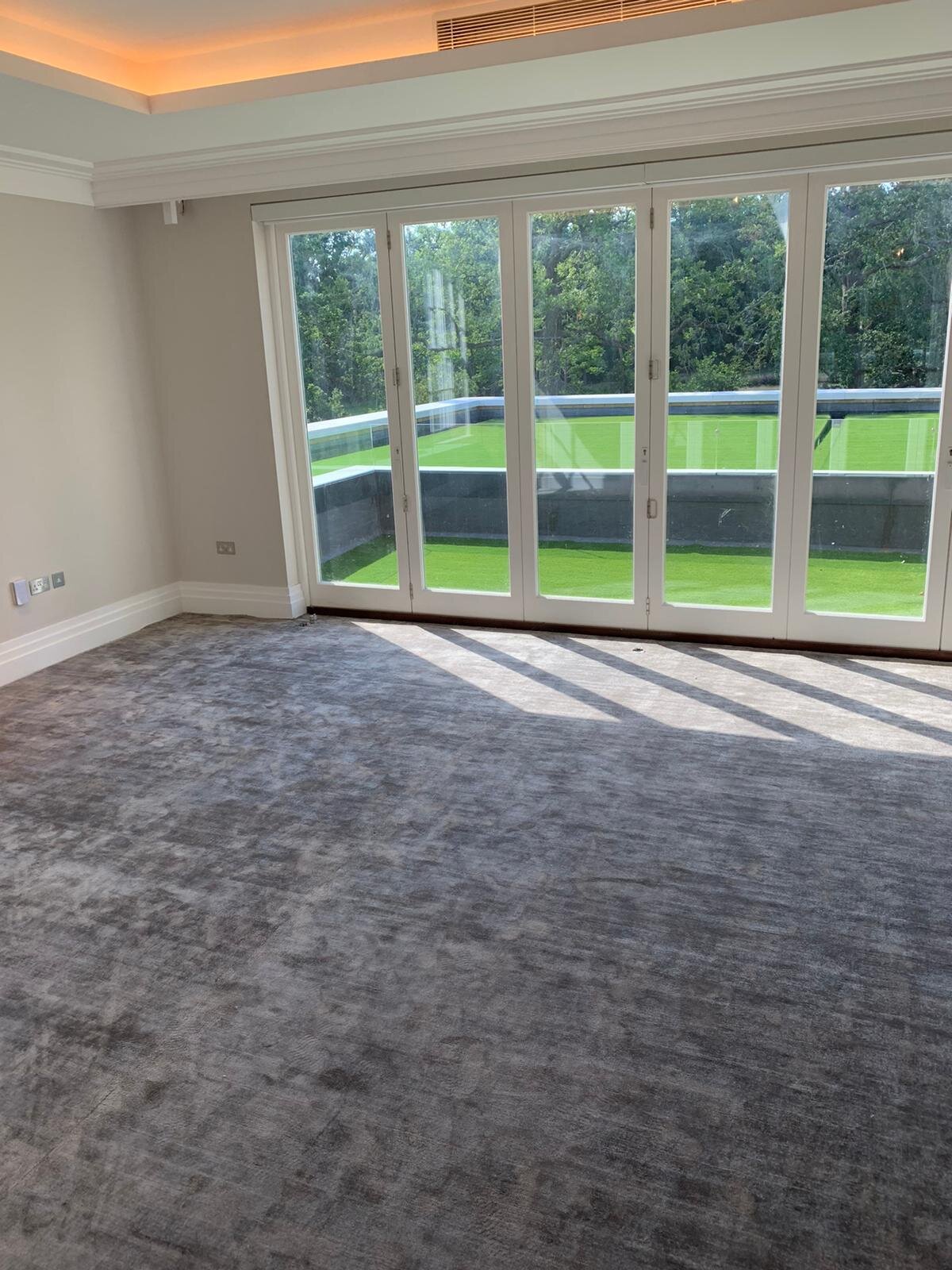 Beautiful bedroom carpet leading out to aritificial lawn on the balcony