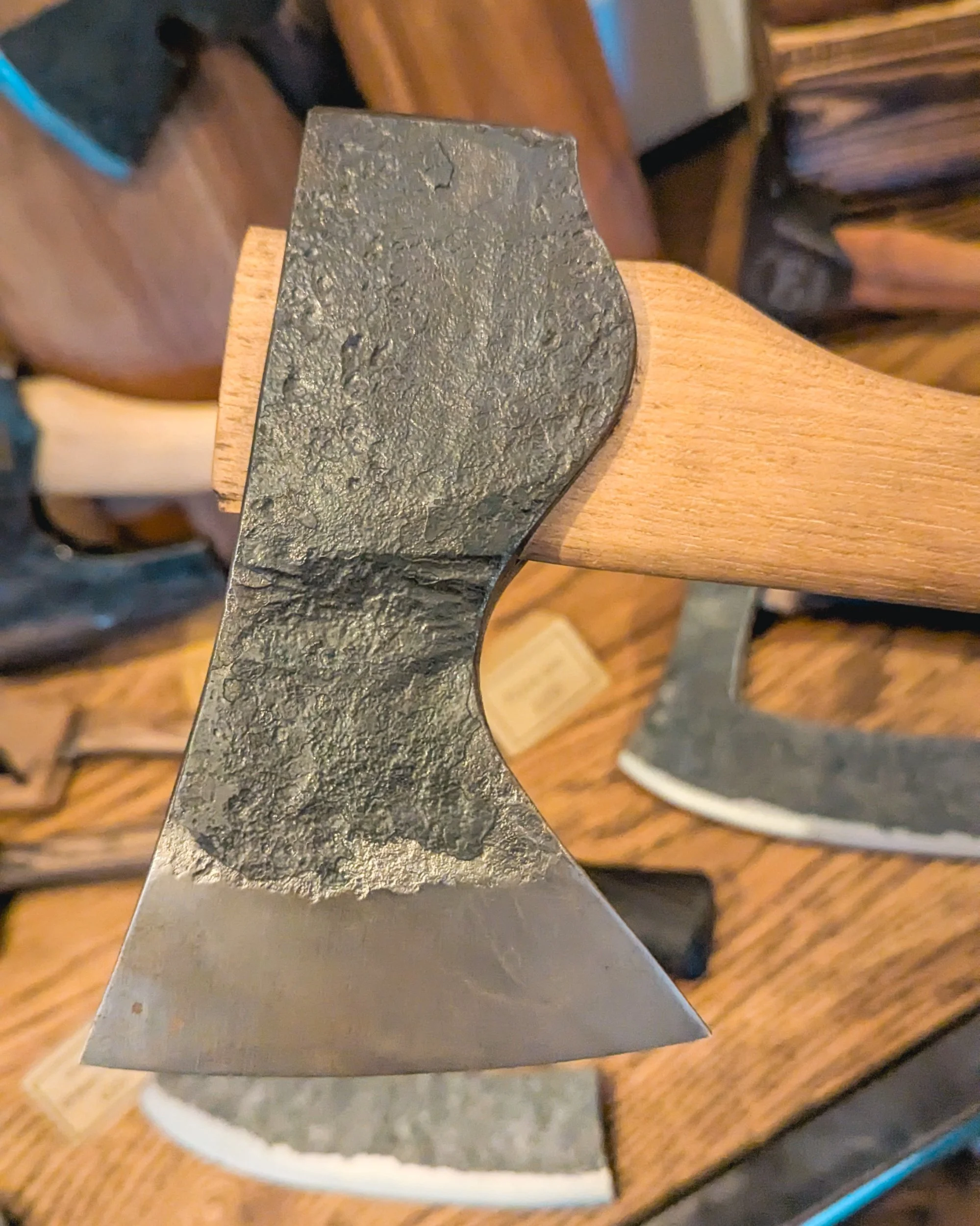 A macro close-up of hand-forged steel, showing the unique dimpled texture and hammer marks that prove the piece was shaped by hand on an anvil.