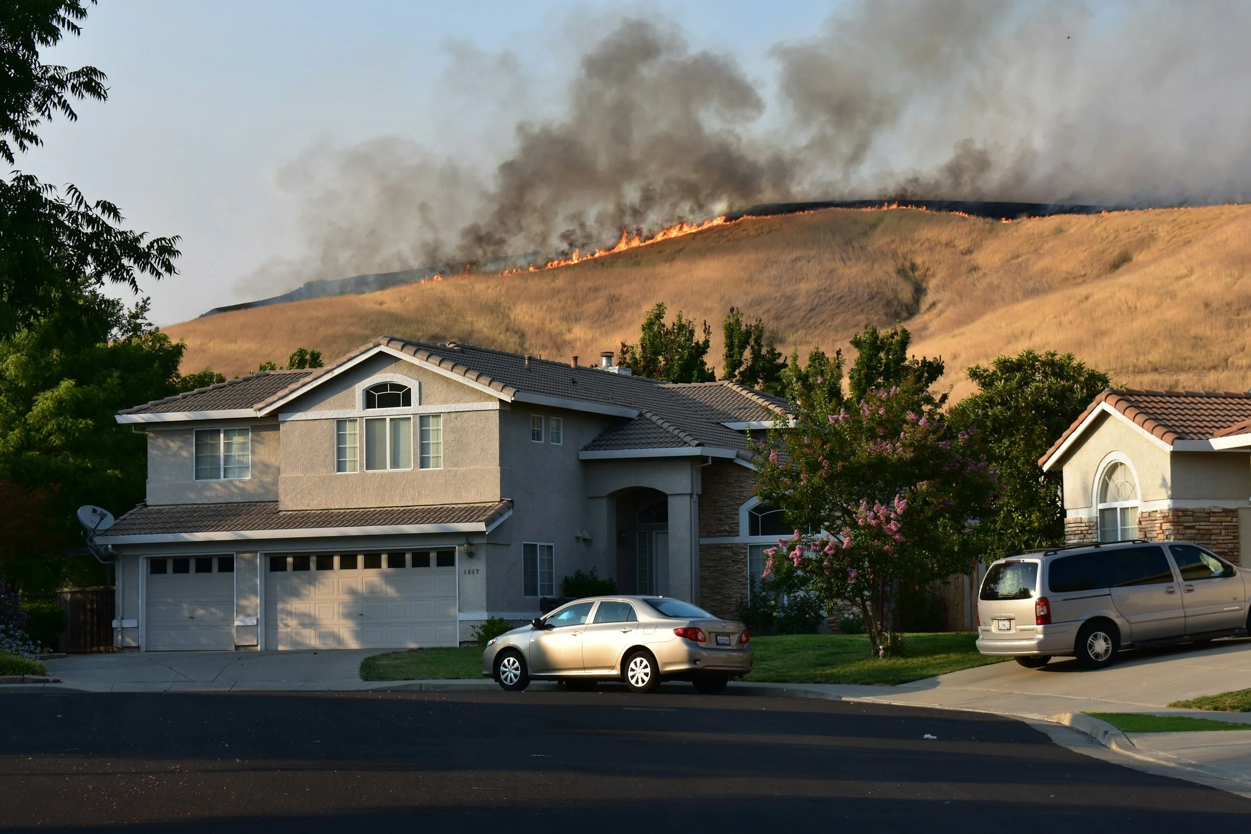 wildfire in a community on hill behind home