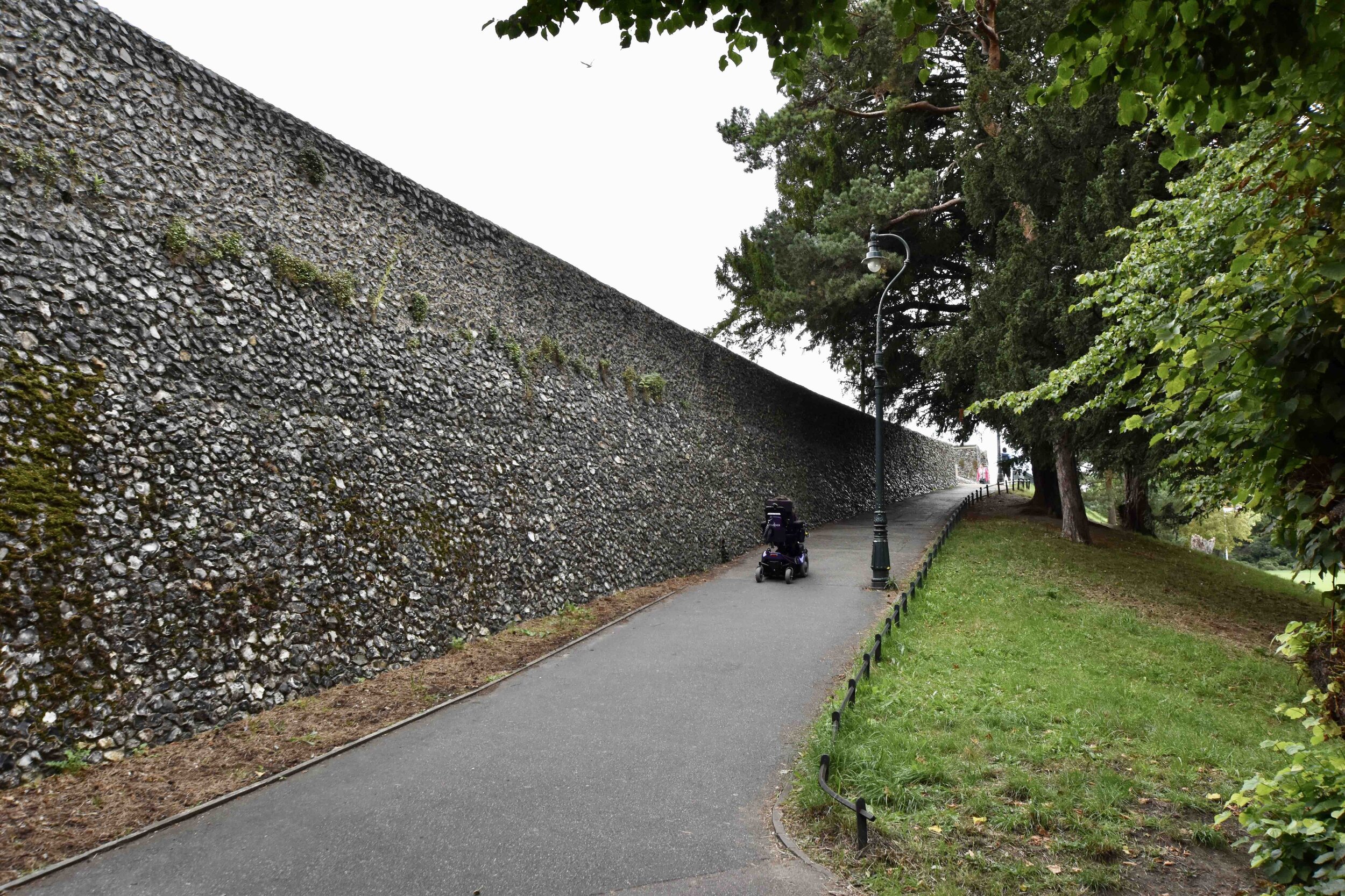 A wheelchair user heading up to the old city wall in Canterbury