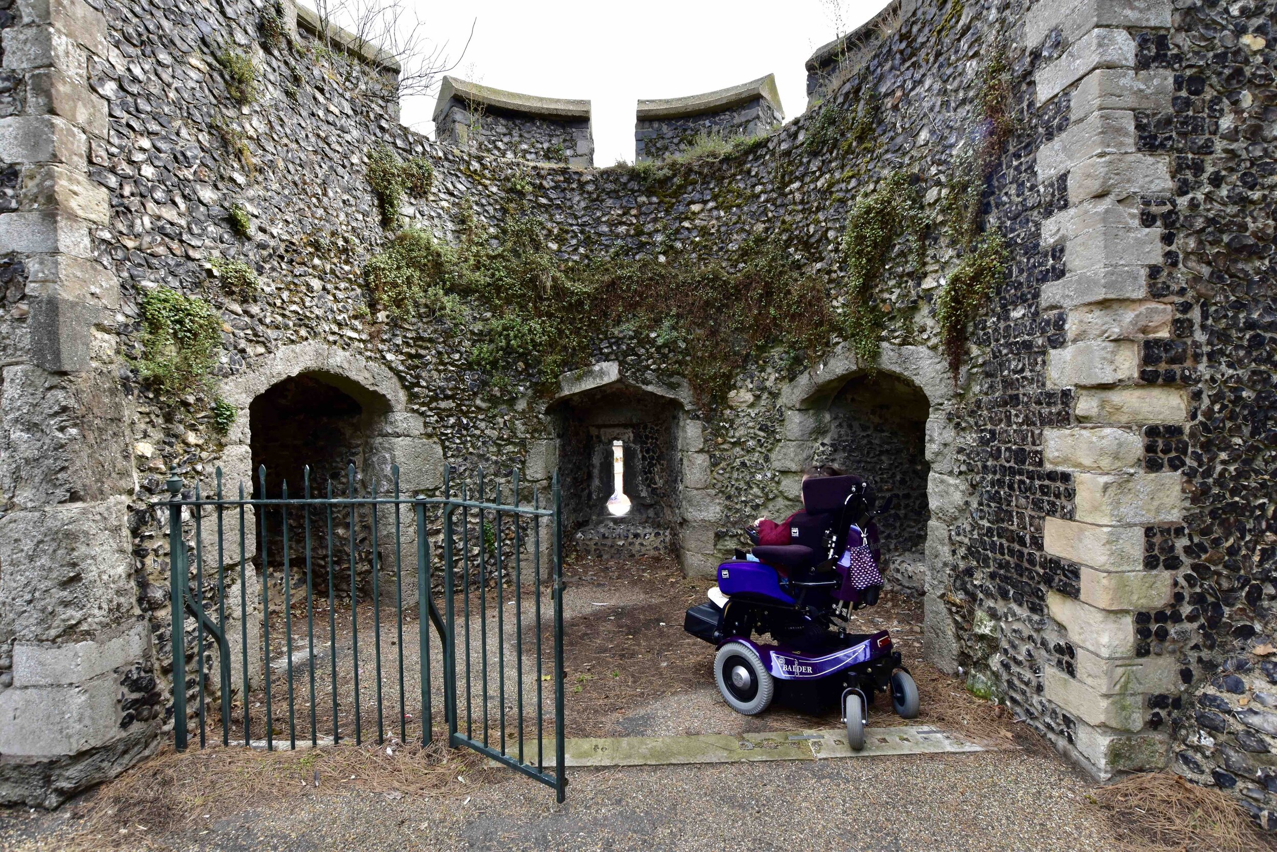  Wheelchair user looking at the gun ports at the old city wall in Canterbury