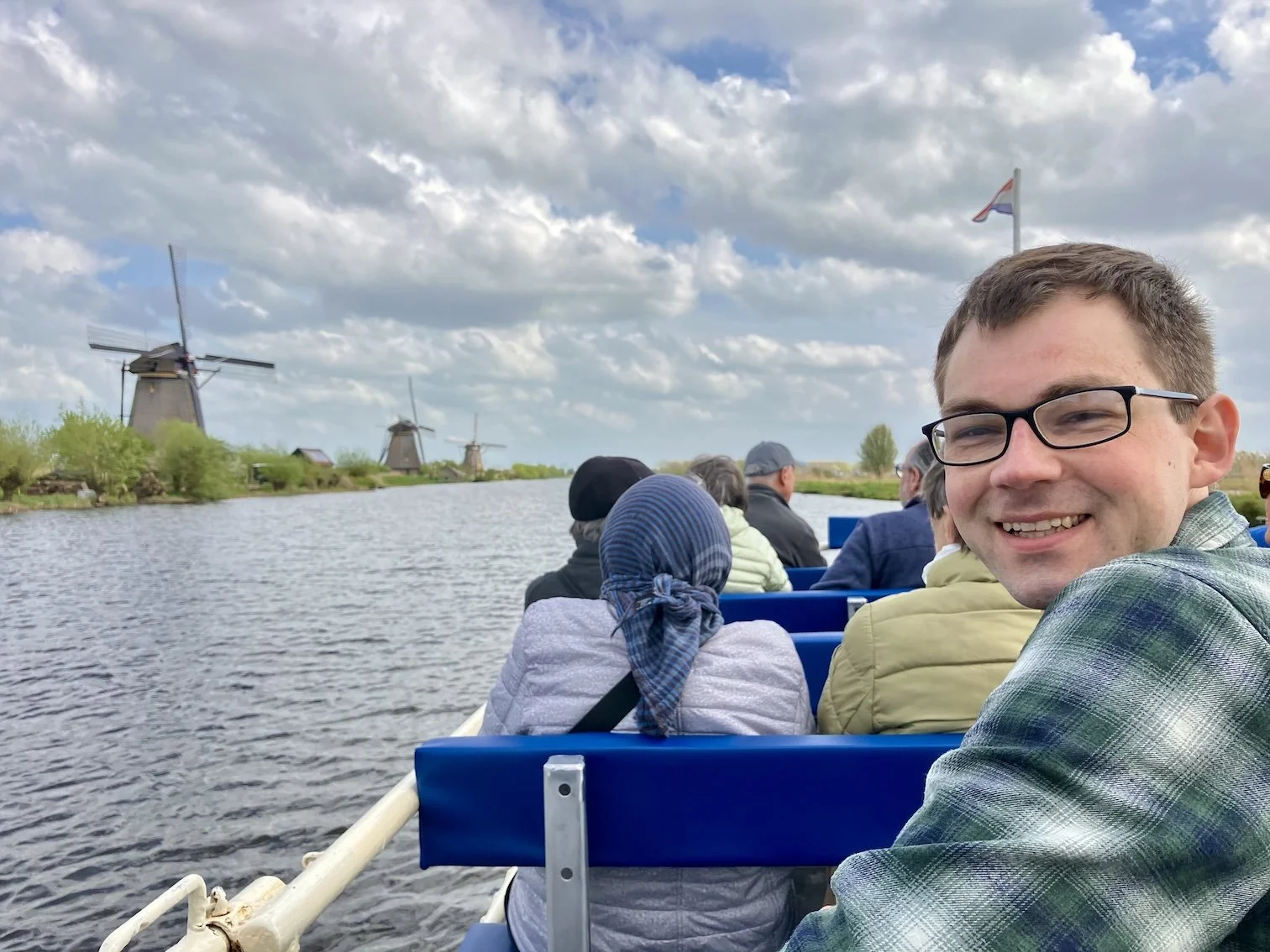  Stephen on a boat at Werelderfgoed Kinderdijk in the Netherlands. A traditional Dutch windmill is behind him 