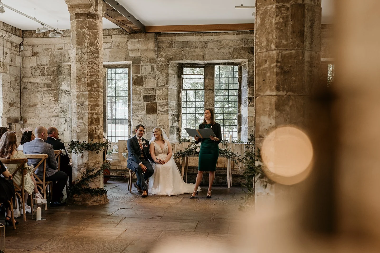 A non-religious wedding ceremony taking place in a Medieval stone hall, led by a Humanist celebrant.
