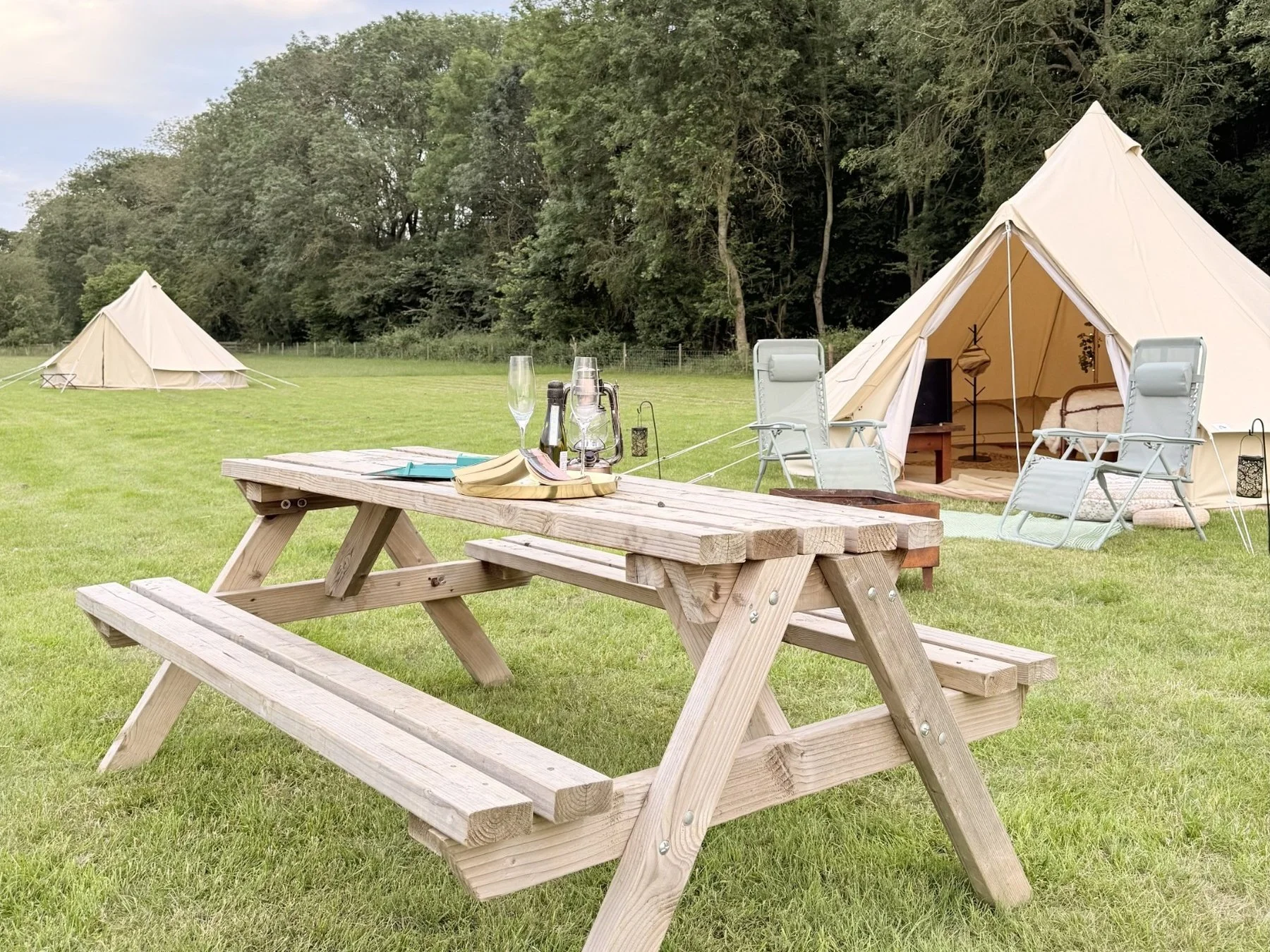 Our bell tents come with recliners, a fire-pit and picnic benches